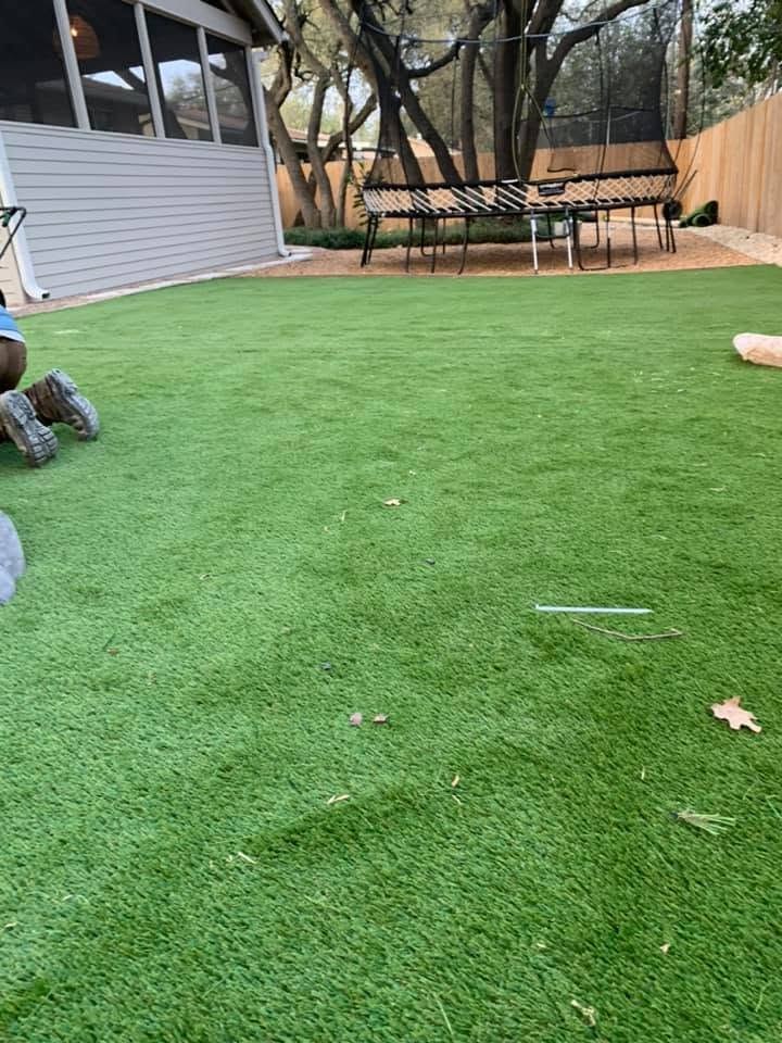 Same backyard with green artificial turf beside the screened porch and trampoline